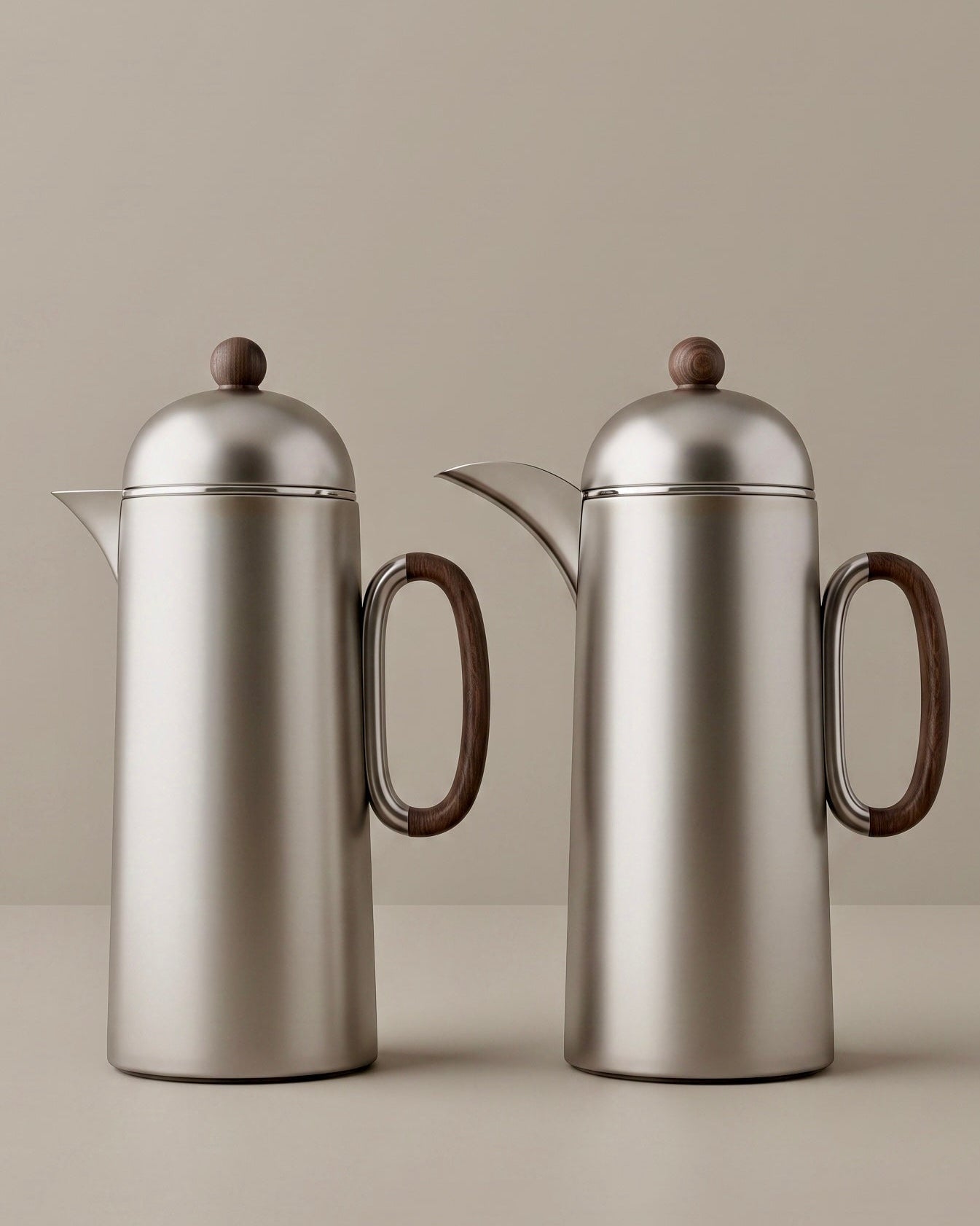 Two silver titanium thermoses with wooden handles on a beige background