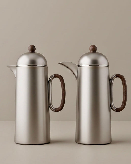 Two silver titanium thermoses with wooden handles on a beige background